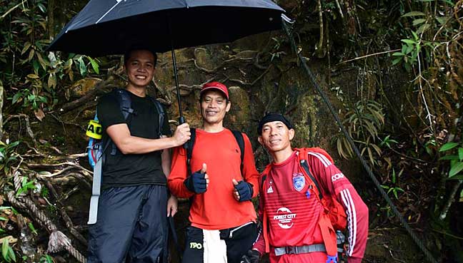 Nazar Yunus (tengah) bersama dua pendaki yang dibawanya menaiki Gunung Santubong di Sarawak.