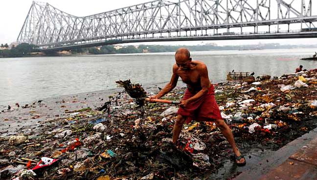 A man cleans garbage along the banks of the river Ganges in Kolkata.