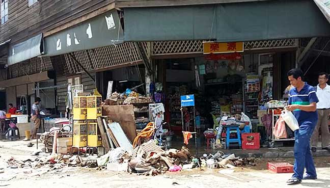 Damaged groceries taken out to the sidewalk after the flood the night before in historic Kinarut town.