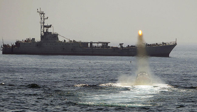 An Iranian warship and speed boats take part in a naval war game in the Persian Gulf and the Strait of Hormuz southern Iran