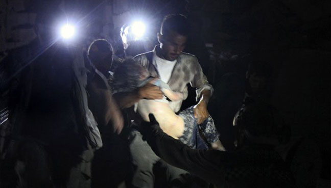 A child is recovered from the rubble of a building in the northern Syrian town of Orum al Kubra which was the target of fierce bombardment