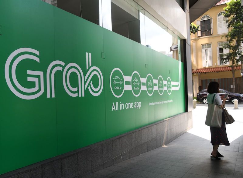 A woman stands outside the Grab transport office in Singapore