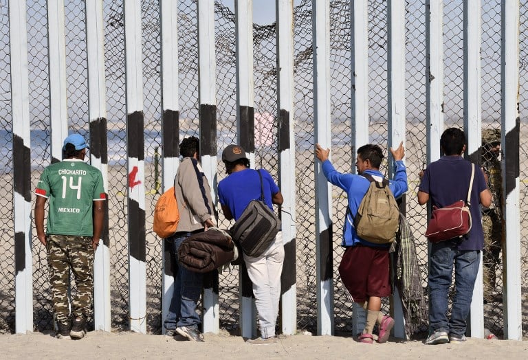 Central American migrants at the US-Mexico border fence in Playas de Tijuana Mexico